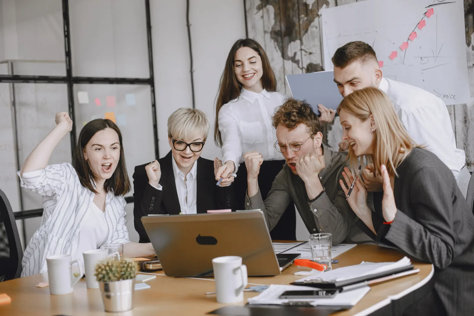 Group of diverse colleagues celebrating success in a modern office