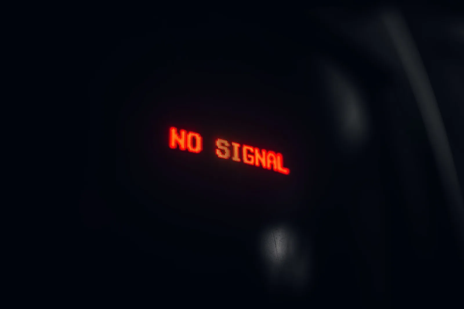 A red LED display indicating 'No Signal' in a dark setting, conveying a tech warning.
